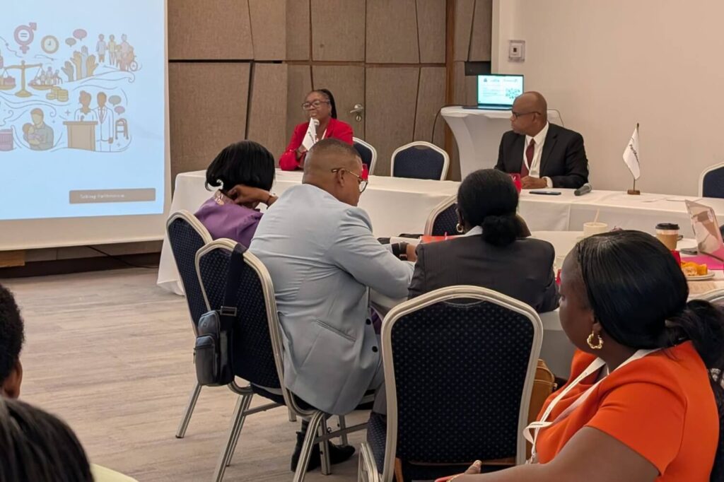 Panel discussion in a conference room with a projector screen on the left.