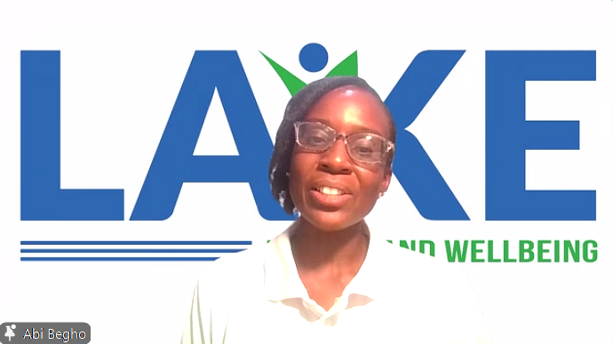 Abi Begho speaks in front of a white background with the blue LAKE logo and green wellbeing text.