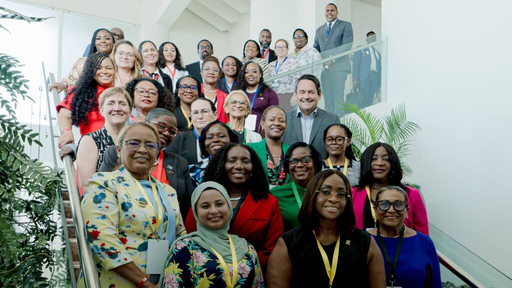 Diverse group of professionals on a stairway posing for a group photo in a bright office setting.